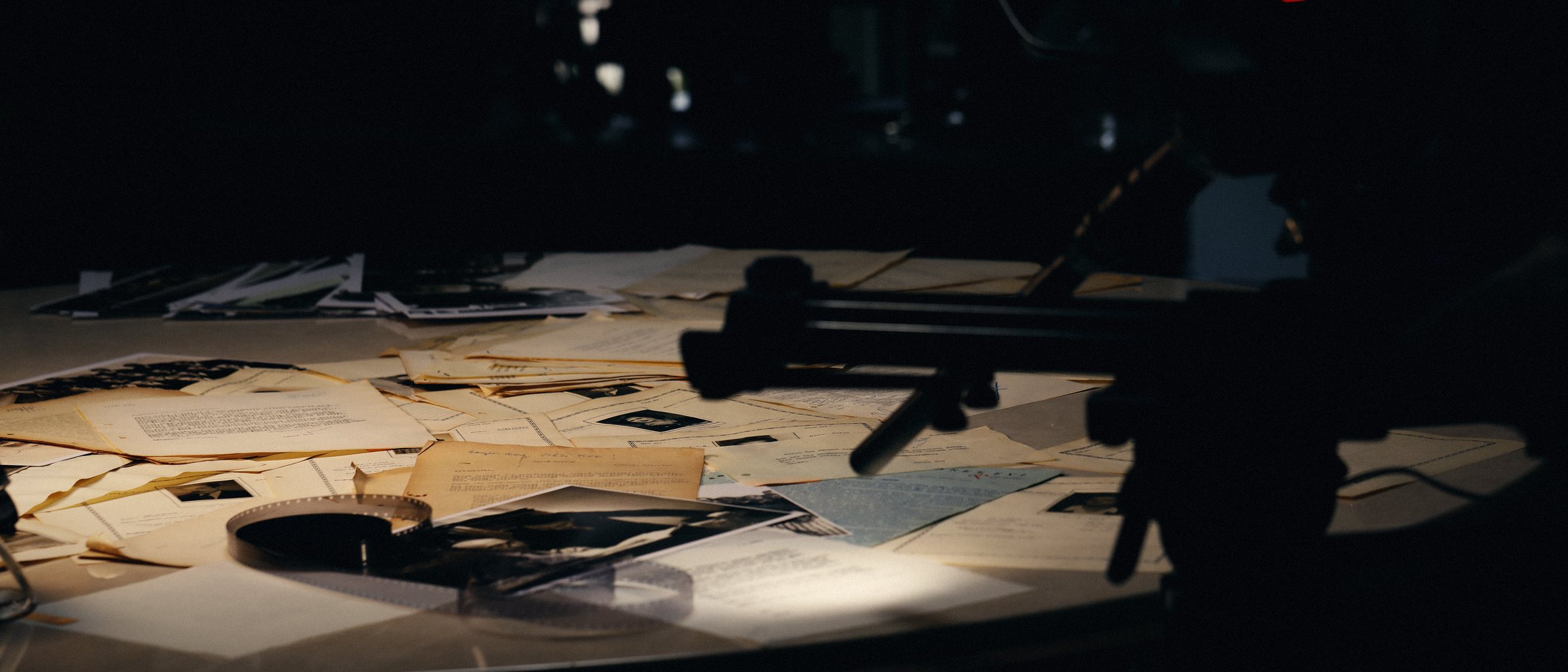 Archive papers and film on a round table lit from above